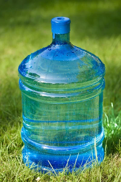 Botella grande de agua sobre fondo de hierba verde —  Fotos de Stock
