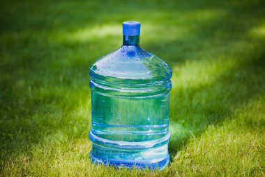 Water bottle on green grass background clipart