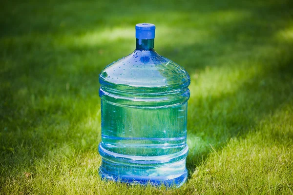 Water bottle on green grass background — Stock Photo, Image