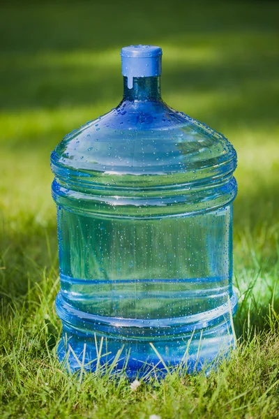 Water big bottle on green grass background — Stock Photo, Image