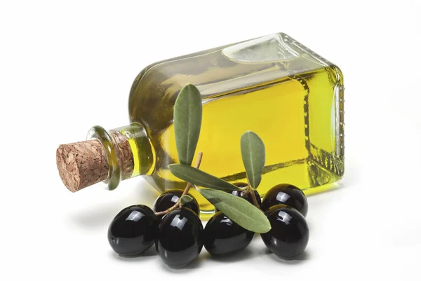 Černé olivy a láhev olivového oleje. — Stock fotografie