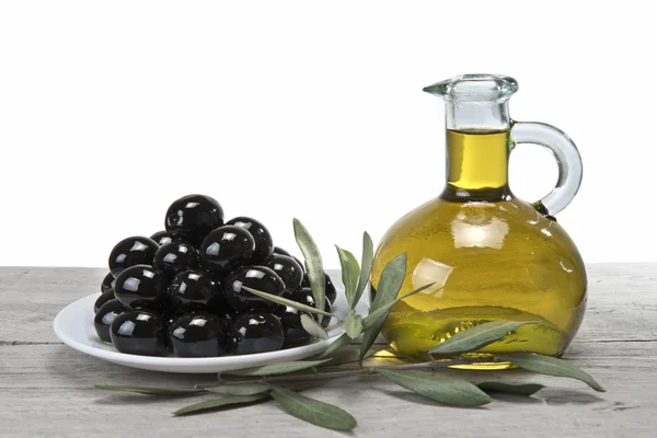 En tallrik med svarta oliver och olja. — Stockfoto
