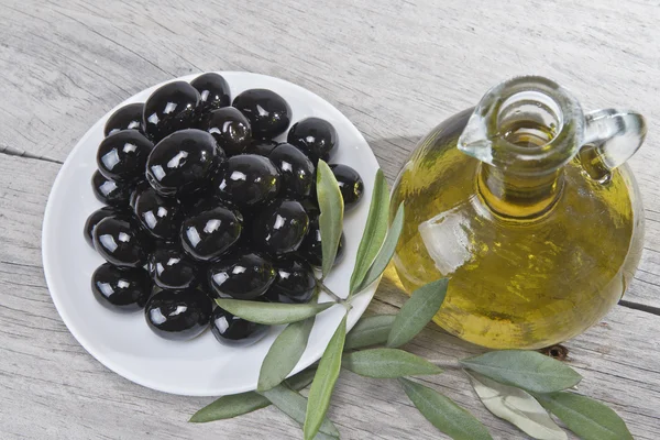 Um prato com azeitonas pretas e óleo . — Fotografia de Stock