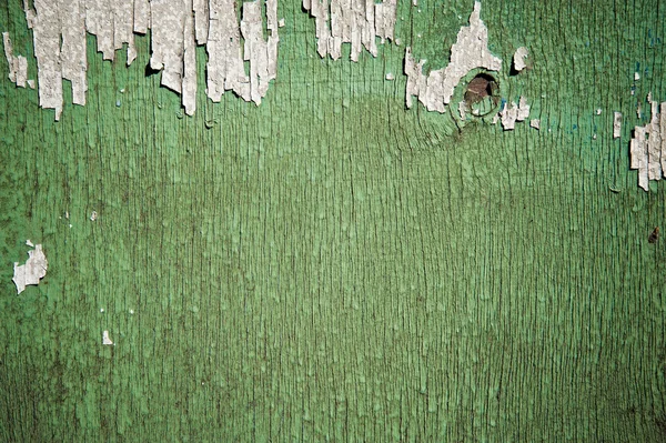 Pintura verde en escamas sobre fondo de madera descolorida — Foto de Stock