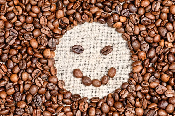 Koffiebonen tevreden glimlach op jute — Stockfoto