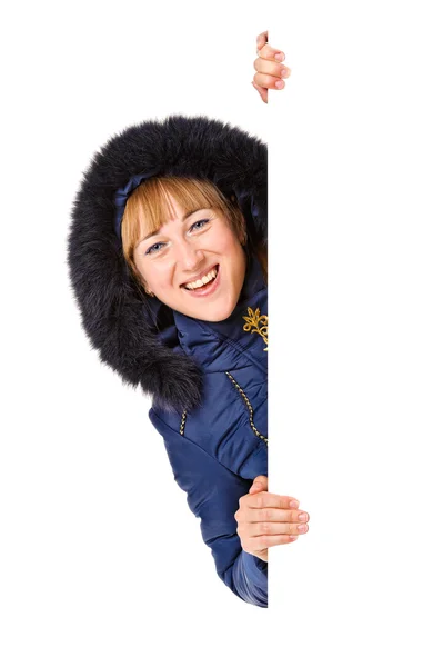 Mulher feliz no inverno azul casaco com capuz segurando a placa em branco — Fotografia de Stock