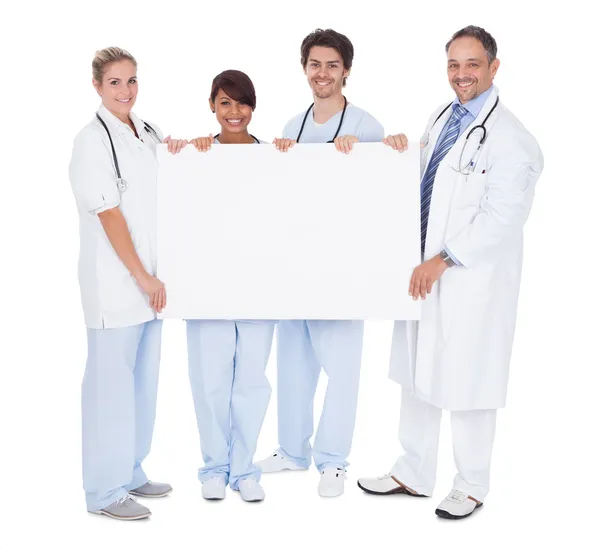Grupo de médicos que apresentam placa vazia — Fotografia de Stock