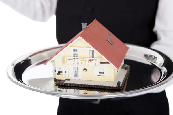 Close-up of a butler with model of a house — Stock Photo, Image