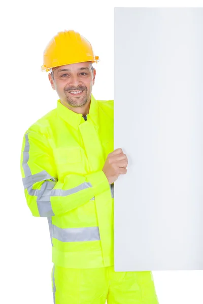 Trabalhador em jaqueta de segurança apresentando placa vazia — Fotografia de Stock