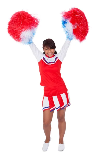 Lachende mooie cheerleader met pompoms — Stockfoto
