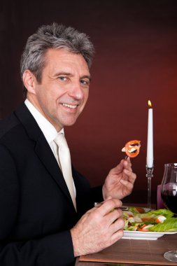 Ensalada de hombre maduro comiendo en el restaurante