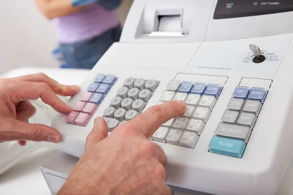 Sales person entering amount on cash register — Stock Photo, Image