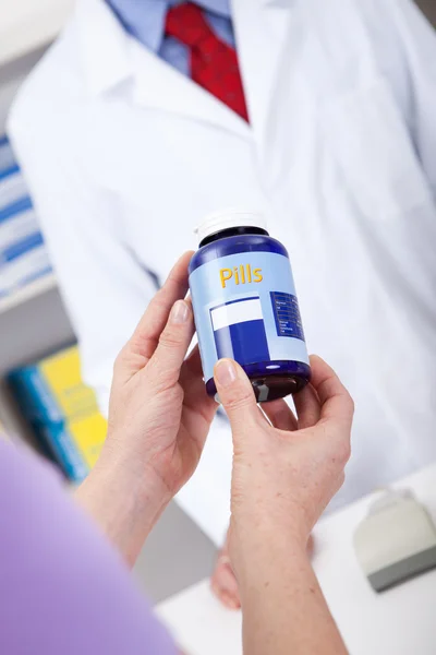 Olhando para recipiente pílula na farmácia — Fotografia de Stock