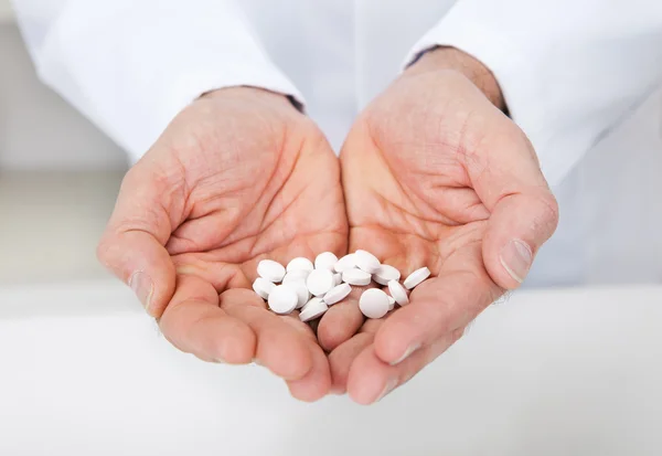 Doctor holding a pills in the hands — Stock Photo, Image