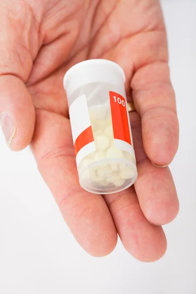 Läkare innehar en piller behållare på apotek — Stockfoto
