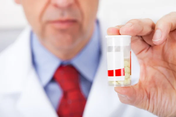 Γιατρός κρατώντας ένα χάπι εμπορευματοκιβώτιο στο φαρμακείο — Φωτογραφία Αρχείου