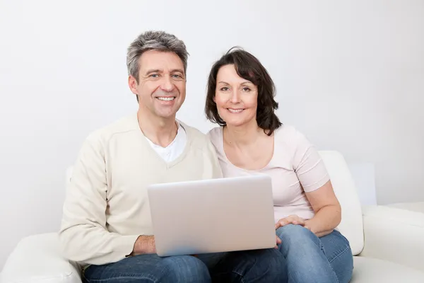 Idős pár használja laptop otthon — Stock Fotó