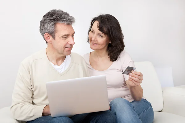 Mogna par som använder laptop hemma — Stockfoto