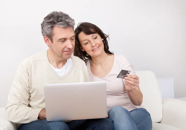 Volwassen paar met behulp van laptop thuis — Stockfoto