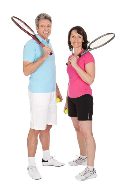 Casal maduro com raquetes de tênis — Fotografia de Stock