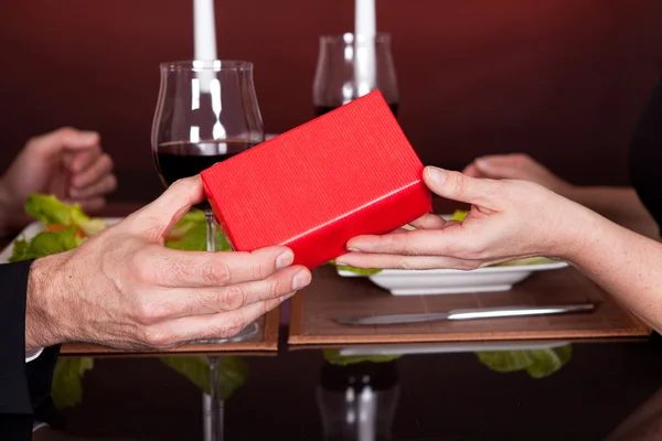 Seorang pria memberikan hadiah untuk seorang wanita di restoran — Stok Foto