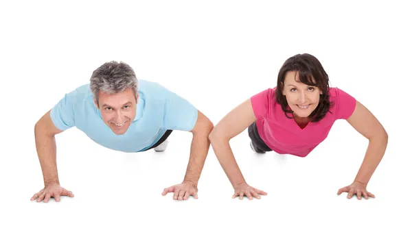Aktiva äldre par gör armhävningar做俯卧撑的活跃成熟夫妇 — 图库照片