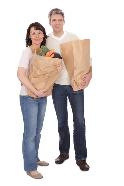 Lyckliga paret med livsmedelsbutiker påsar — Stockfoto