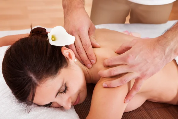 Beautiful young woman getting shoulder massage — Stock Photo, Image