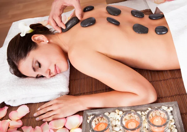 Beautiful young woman getting hot stone therapy — Stock Photo, Image
