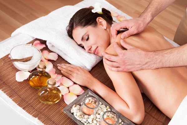 Beautiful young woman getting shoulder massage — Stock Photo, Image