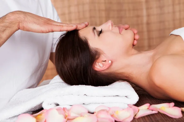 Beautiful young woman getting face massage — Stock Photo, Image