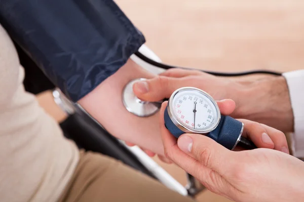 Médico revisando presión arterial — Foto de Stock