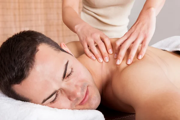 Young man getting shoulder massage Stock Image
