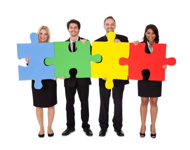 Group of business assembling puzzle