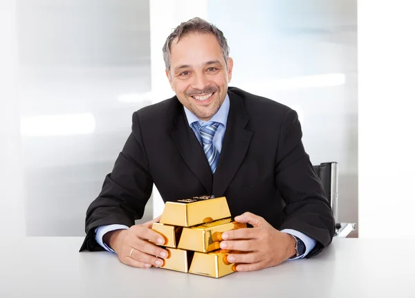 Empresário com barras douradas — Fotografia de Stock
