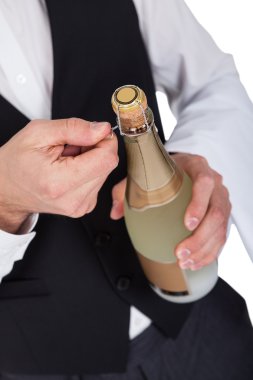 Close-up of butler opening bottle clipart