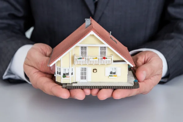 Affärsman presentera hus modell — Stockfoto