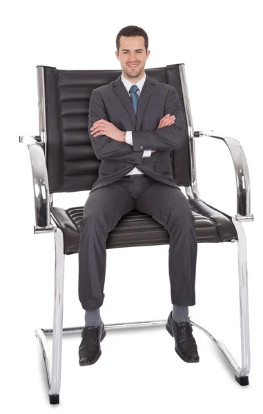 Бизнесмен, сидящий в огромном кресле — стоковое фото