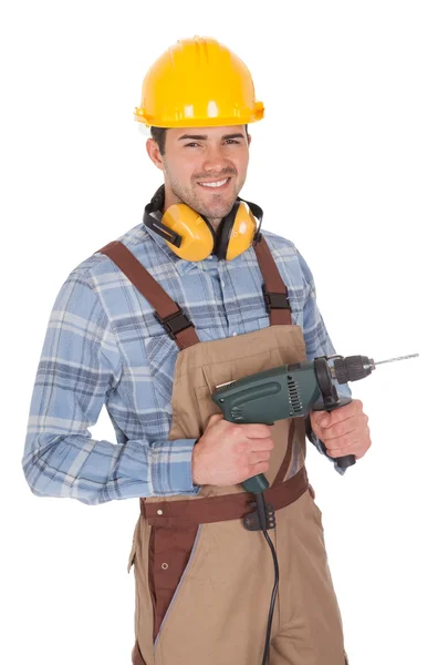 Worker holding drill and wearing hard hat — Stock Photo, Image