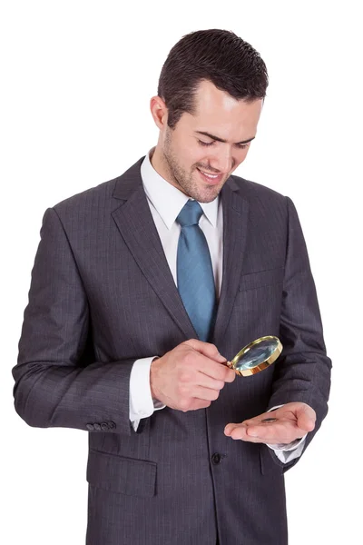Бізнесмен дивиться на одну монету євро через Лупе — стокове фото