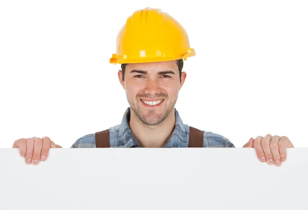Trabalhador usando chapéu duro e segurando banner vazio — Fotografia de Stock
