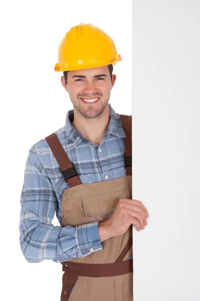 Trabajador vistiendo sombrero duro y sosteniendo banner vacío — Foto de Stock