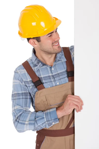 Trabalhador usando chapéu duro e segurando banner vazio — Fotografia de Stock