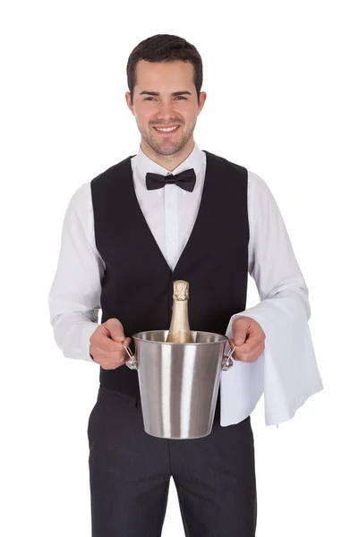 Cheerful butler holding bottle of champagne — Stock Photo, Image