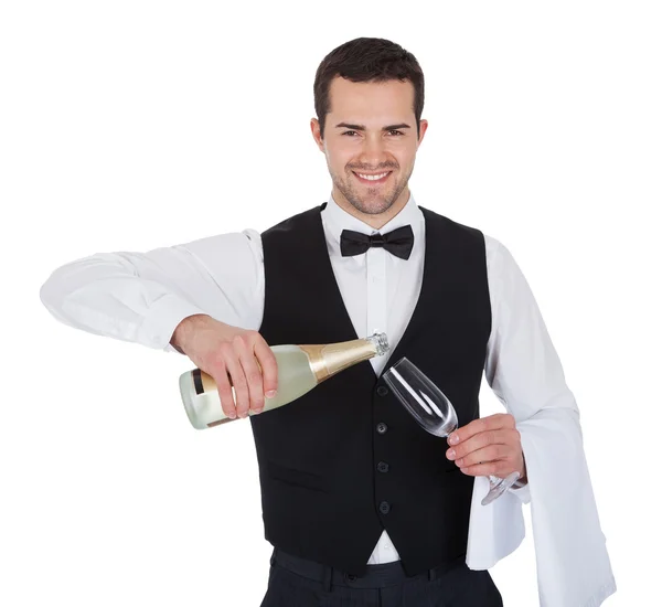 Portrait of butler pouring champagne into glass — Stock Photo, Image