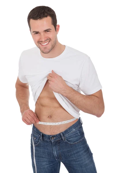 Hombre musculoso midiendo cintura —  Fotos de Stock