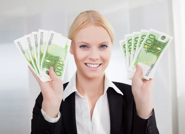 Предпринимательница, держащая банкноты евро — стоковое фото