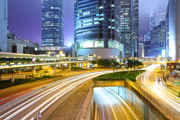 Trafik med oskärpa ljus genom staden på natten — Stockfoto