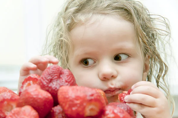 Barn med en jordgubbe — Stockfoto
