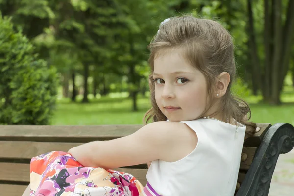 Ребенок на скамейке в парке — стоковое фото